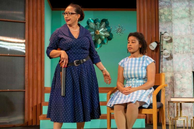 Social worker with gun belt speaking to young woman sitting on a chair.