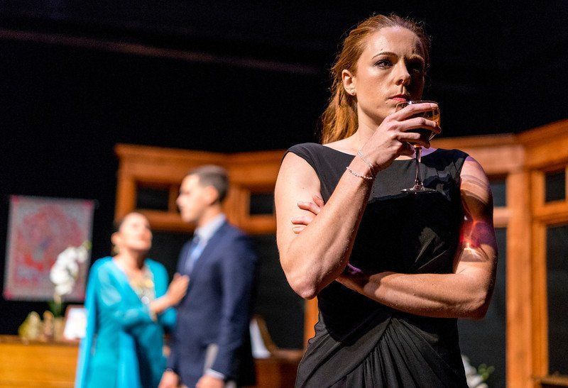 Blurred background of woman in blue and man in blue jacket with close-up of woman in black dress