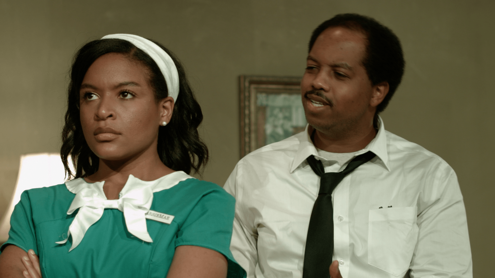 A man and a woman are standing next to each other in a room .