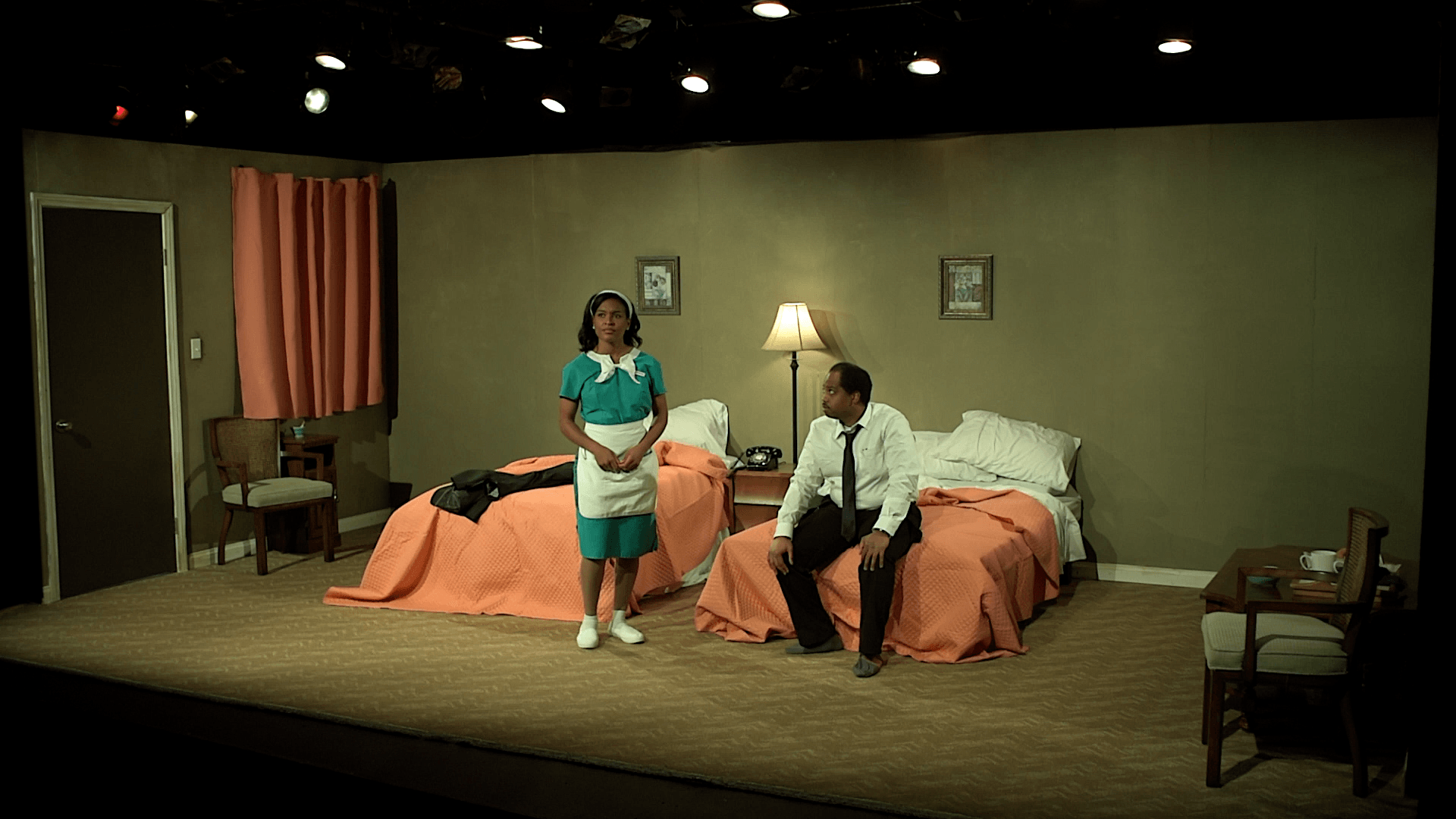 A man and a woman are standing next to each other in a hotel room.