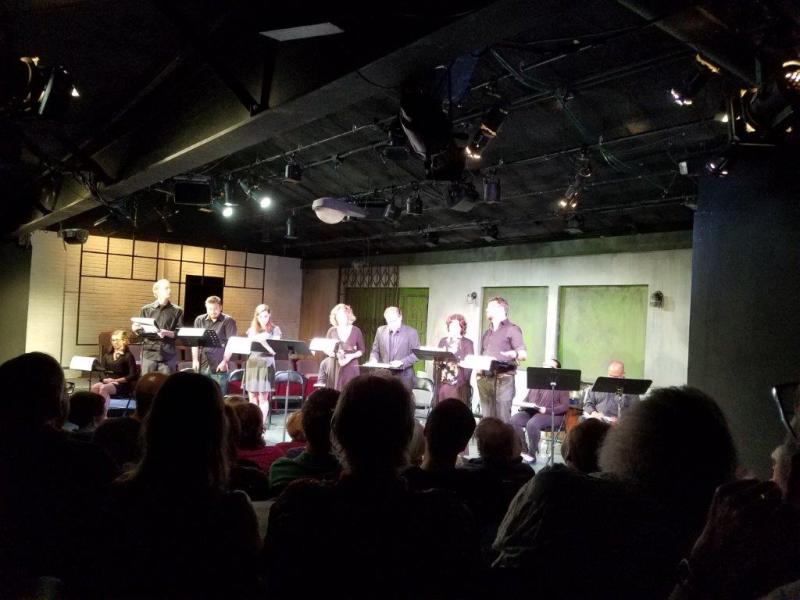 7 actors standing at music stands during a scene.
