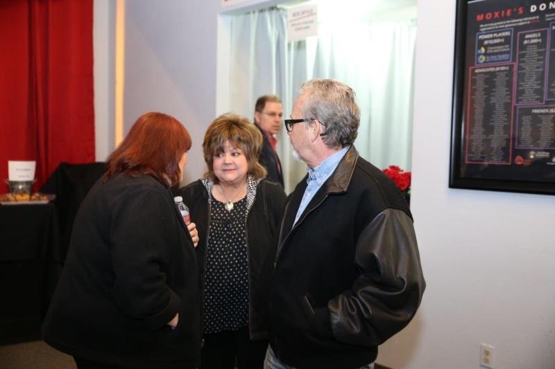 3 audience members talking in theatre lobby after play reading.