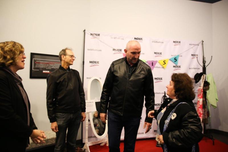 4 guests talking in theatre lobby after play reading.
