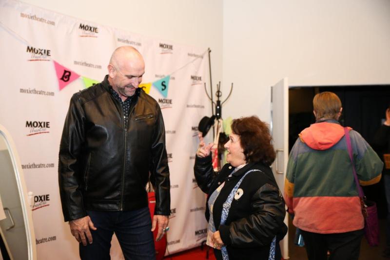 Ruff Yeager talking with attendee in theatre lobby after play reading.