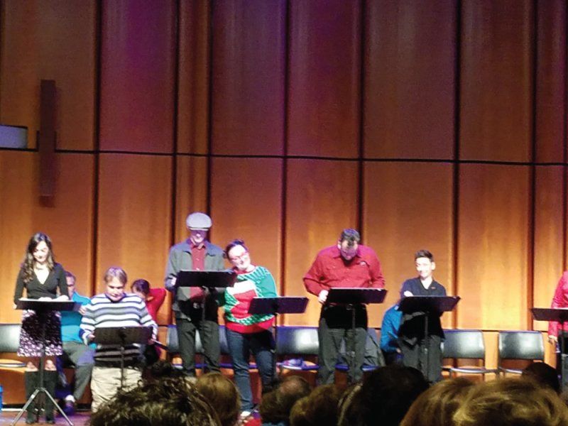 10 actors on stage at music stands or seated with audience watching.