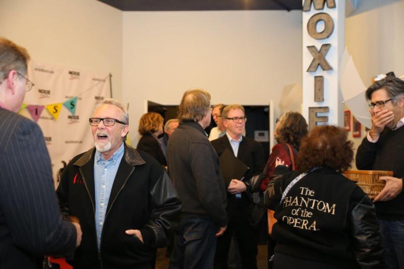 Guests happily greeting each other in MOXIE theatre lobby after reading.