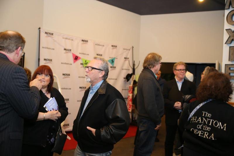 Attendees enjoying conversation in MOXIE theatre lobby after reading.