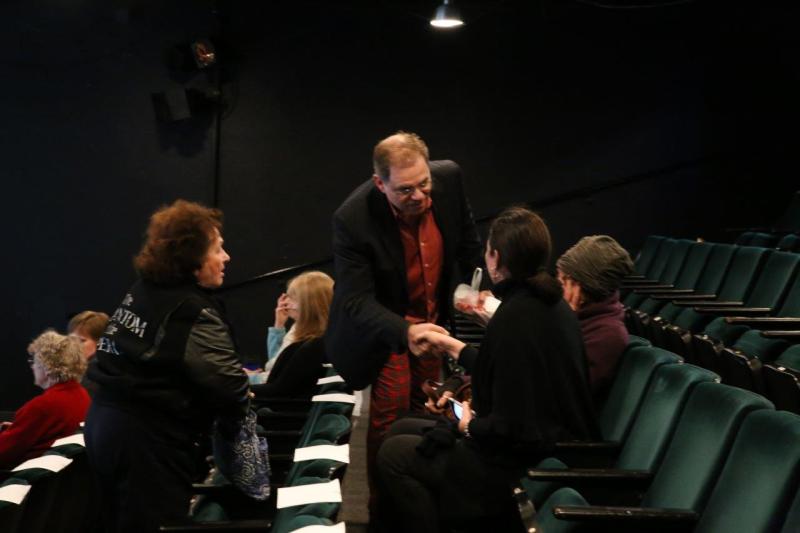 Phil greeting attendees seated in theatre before the reading.