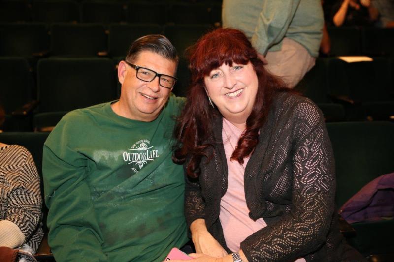 2 attendees seated in theatre waiting for the reading to begin.