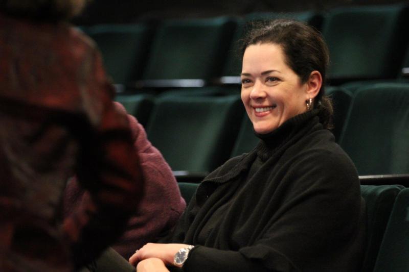 Attendee smiling in the theatre waiting for the reading to begin.