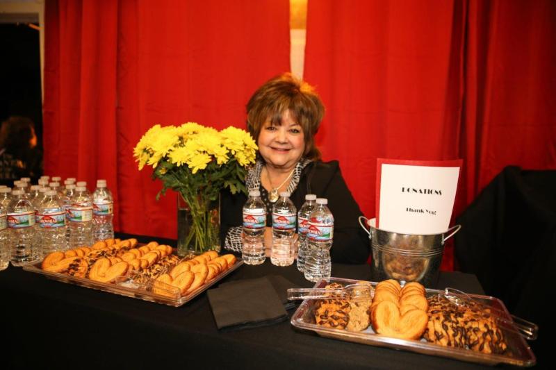 Julie seated behind flowers at concessions table.
