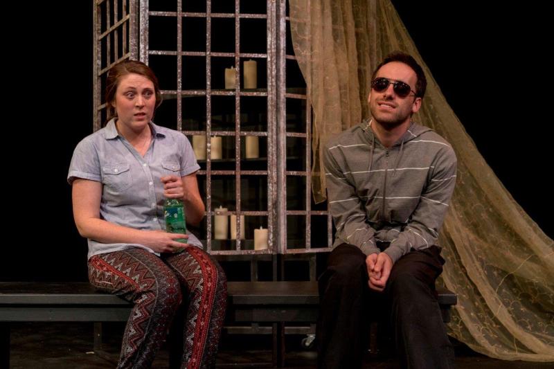 Woman in short-sleeved blouse  talking to man in sunglasses and striped hoodie.