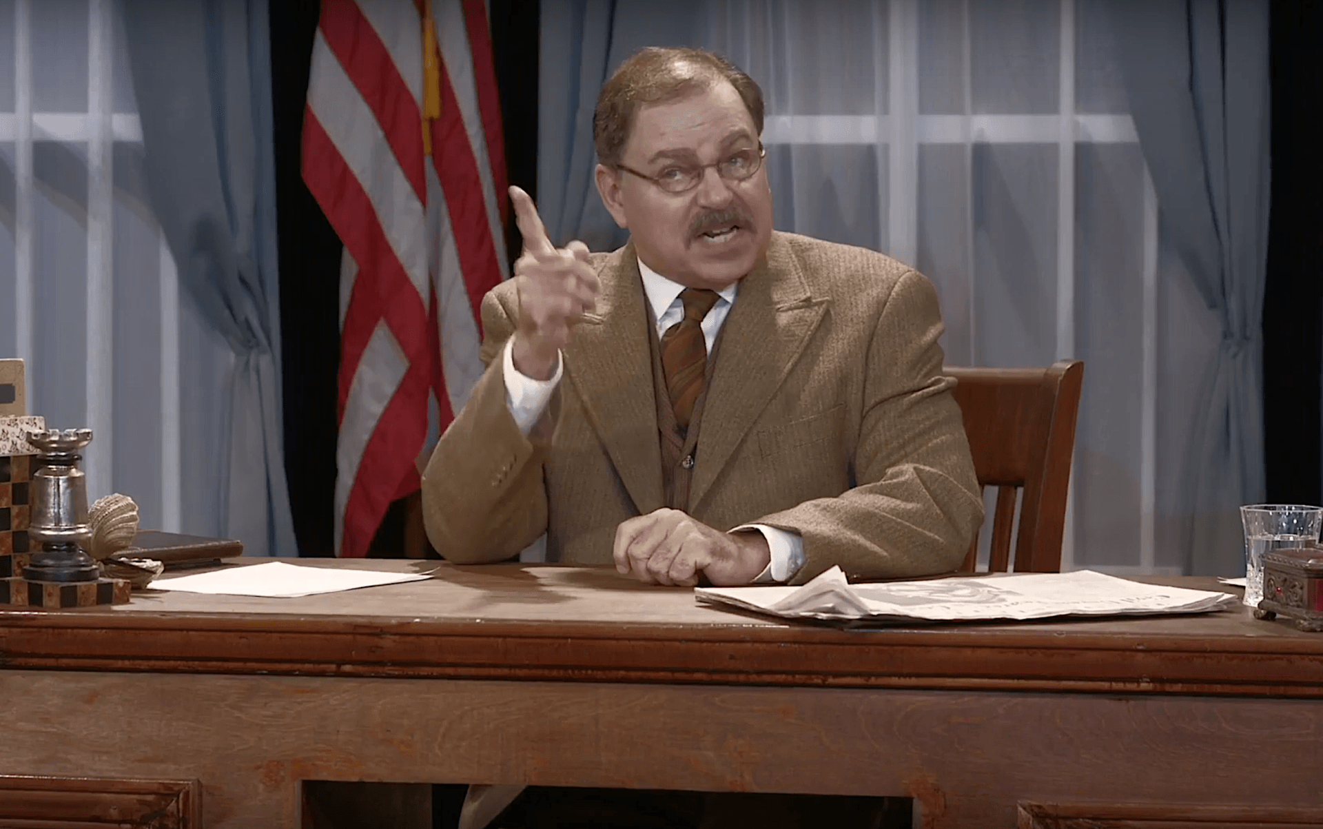 Actor Phil Johnson as President Theodore Roosevelt  sitting at his desk in his White House office.