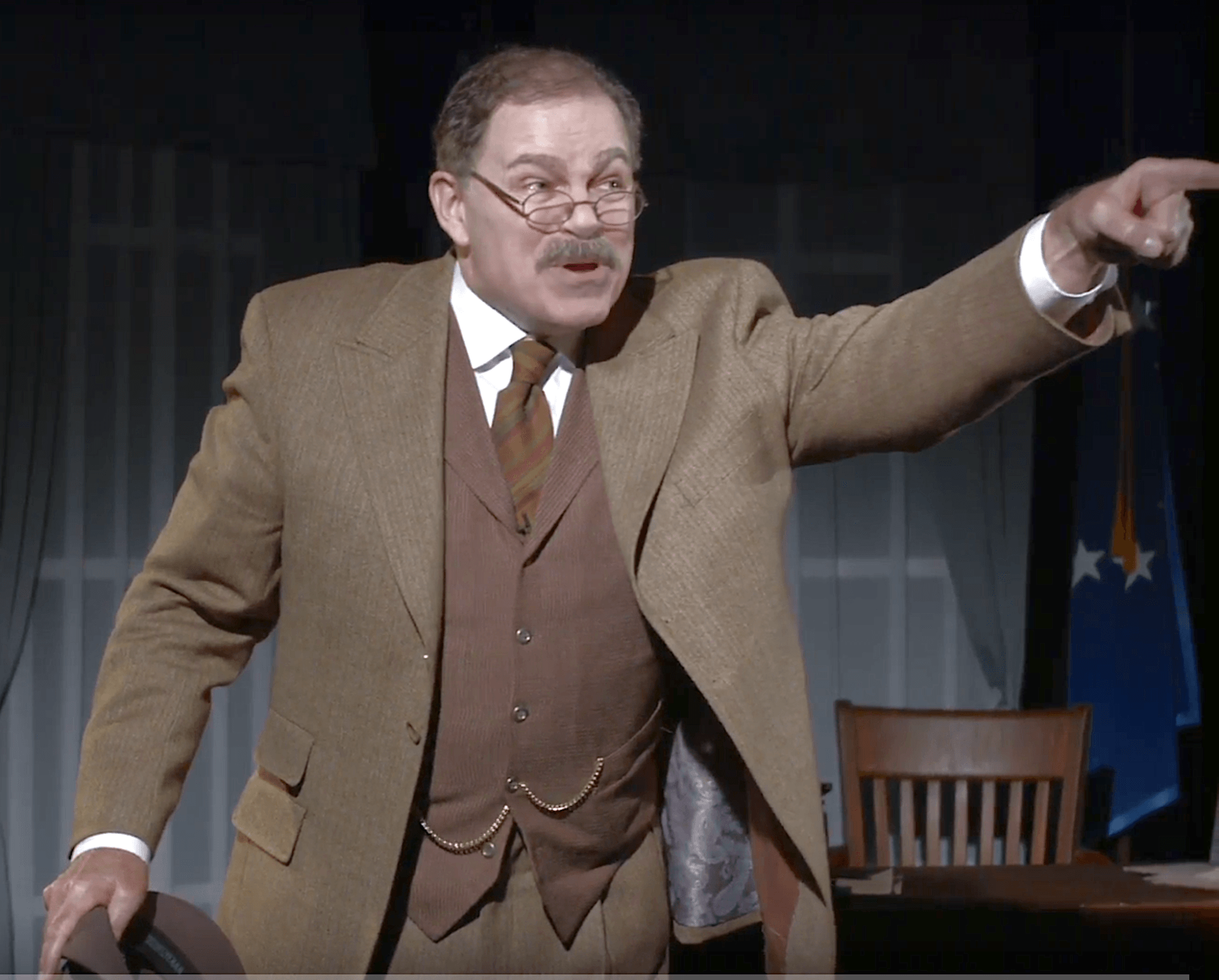 Actor Phil Johnson as President T. Roosevelt speaking to reporters in his office.