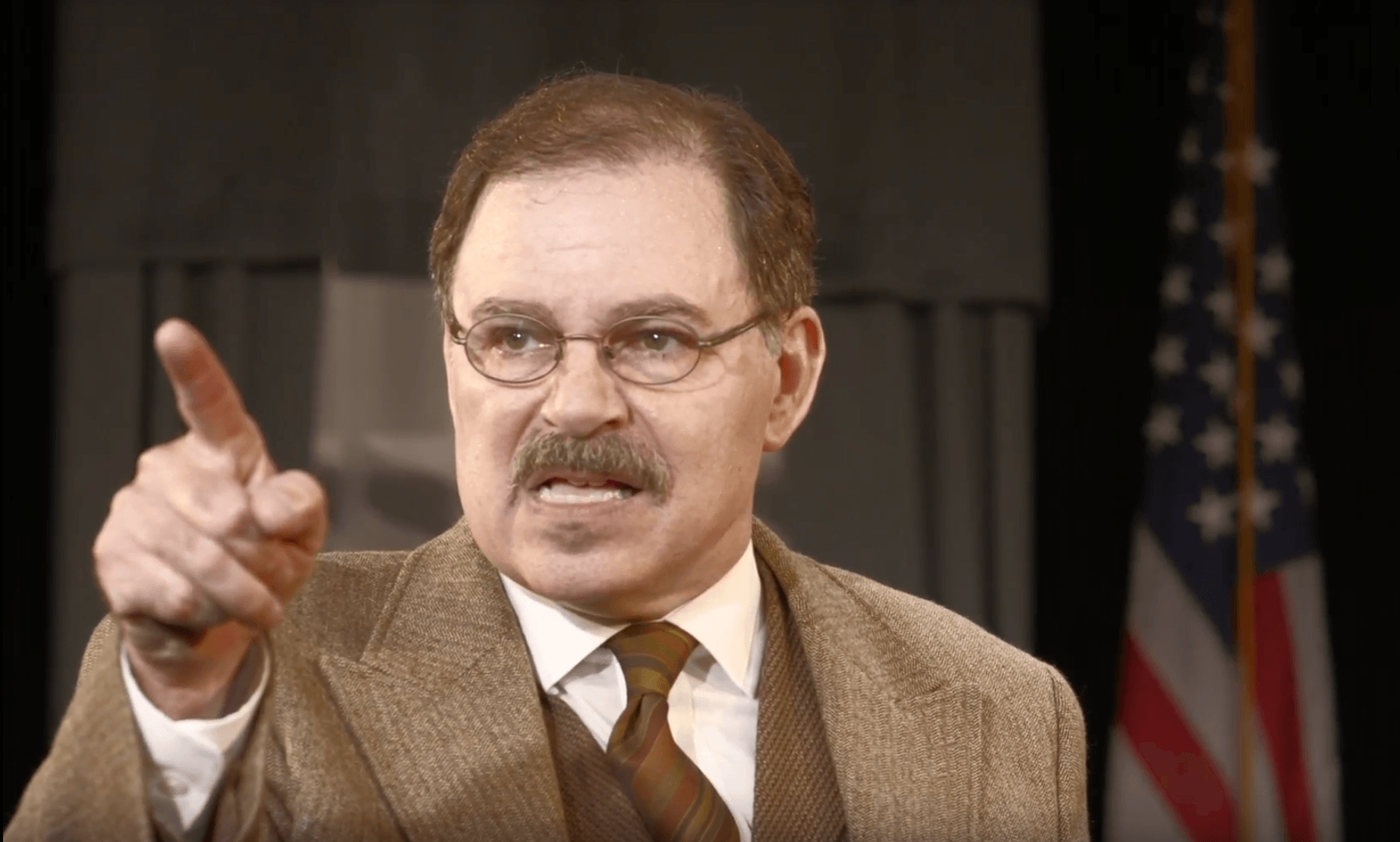 Actor Phil Johnson portraying President Theodore Roosevelt speaking forcefully to  the crowd.