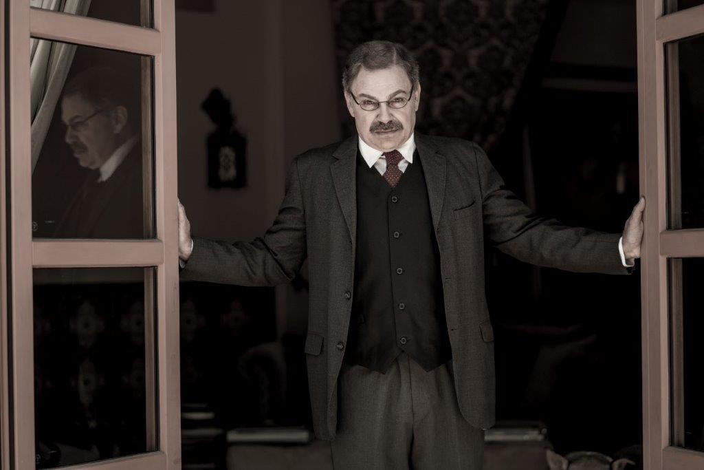 Actor Phil Johnson as President T. Roosevelt standing in open doorway addressing crowd