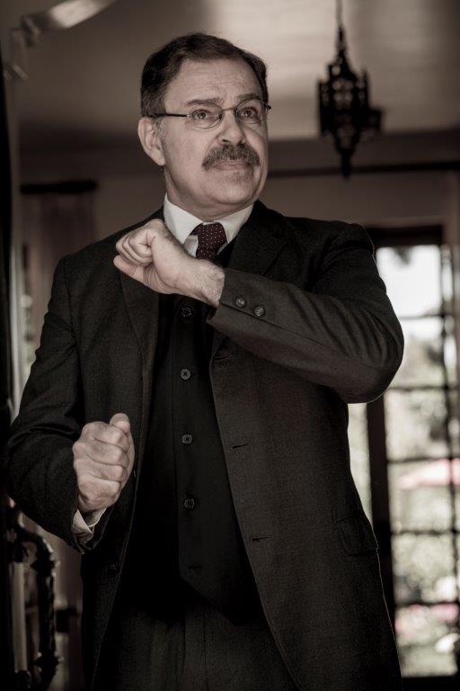 Actor Phil Johnson as President T. Roosevelt standing in open doorway giving speech