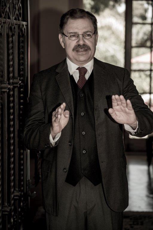 Actor Phil Johnson as President T. Roosevelt standing in open doorway speaking
