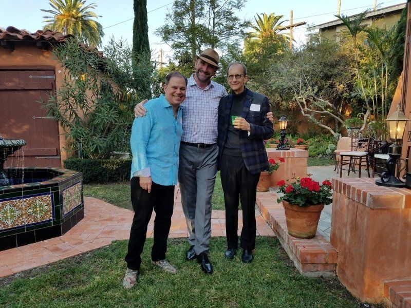 3 co-founders of The Roustabouts Theatre Co. at standing outdoors at party