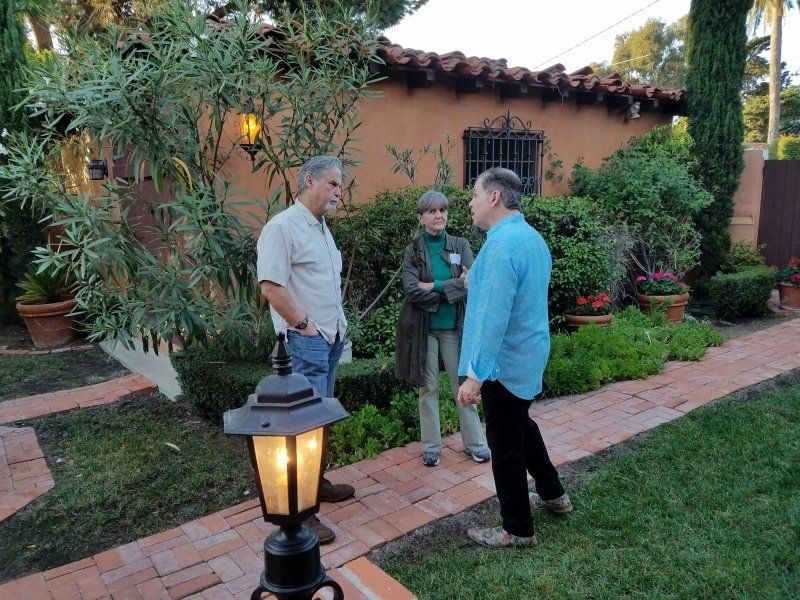 2 guests and host Phil standing outdoors at party
