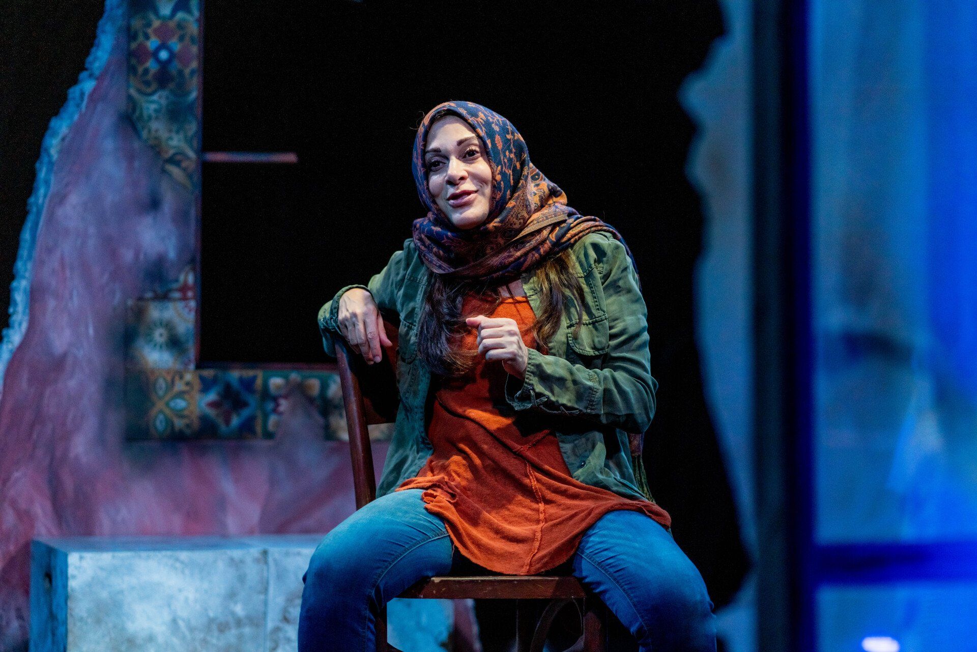 Young Mahshid seated with left hand in front of her chest.