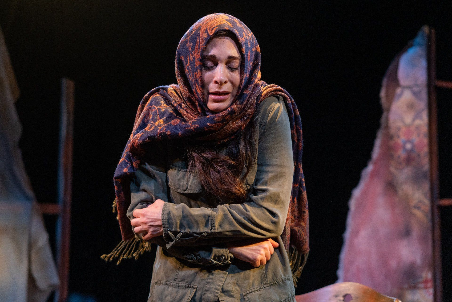 Young Mahshid looking cold wearing headscarf and green jacket.