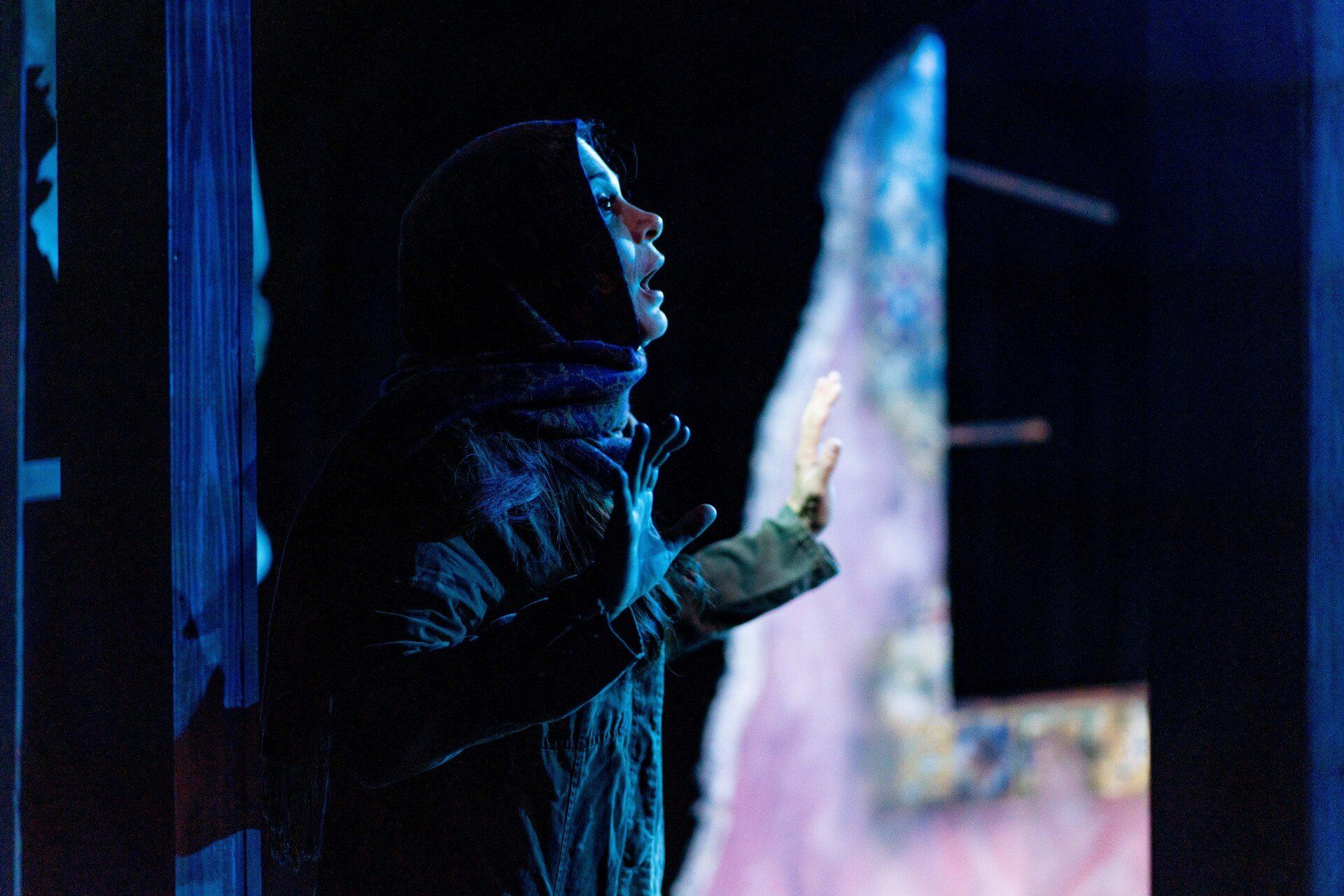 Young Mahshid standing in shadow.