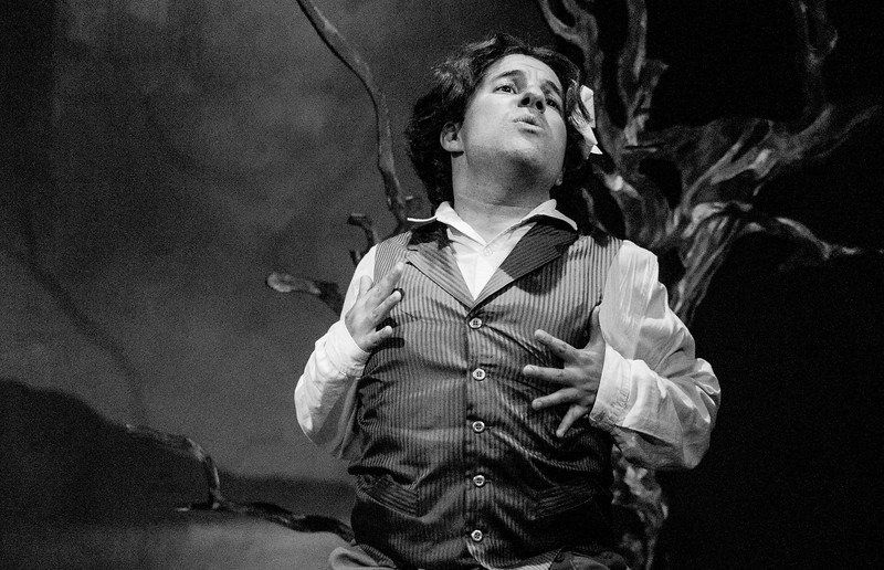 B&W of man in blue wig and vest in a scene from Withering Heights play.