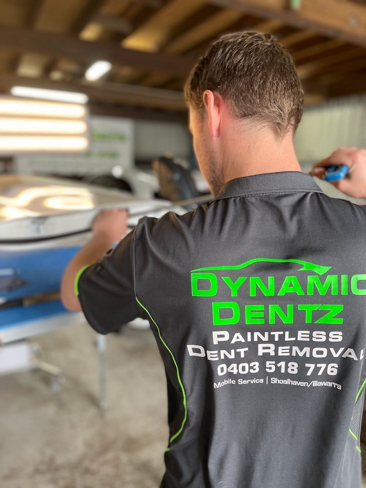 A man is wearing a work shirt that says Dynamic Dentz Smash Repair on the back — Dynamic Dentz Smash Repair in South Nowra, NSW