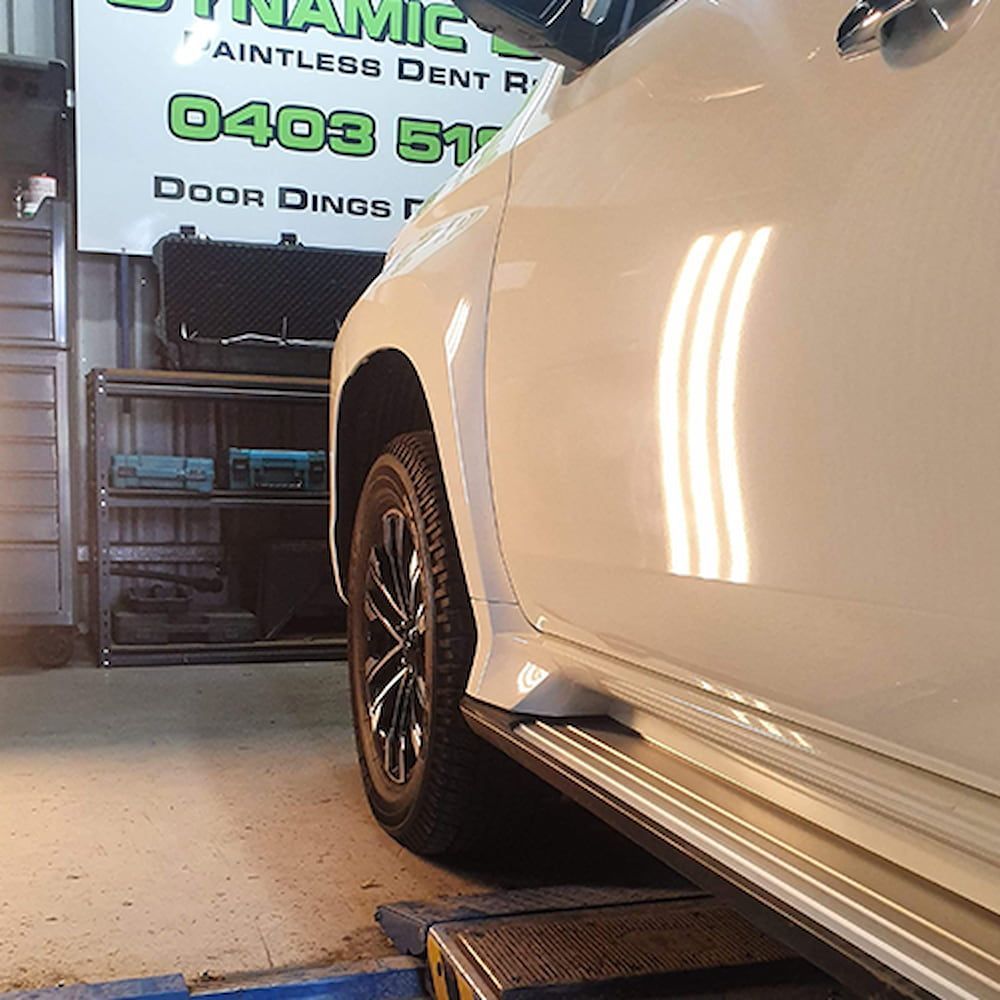 A white car with light shining on it — Dynamic Dentz Smash Repair in South Nowra, NSW