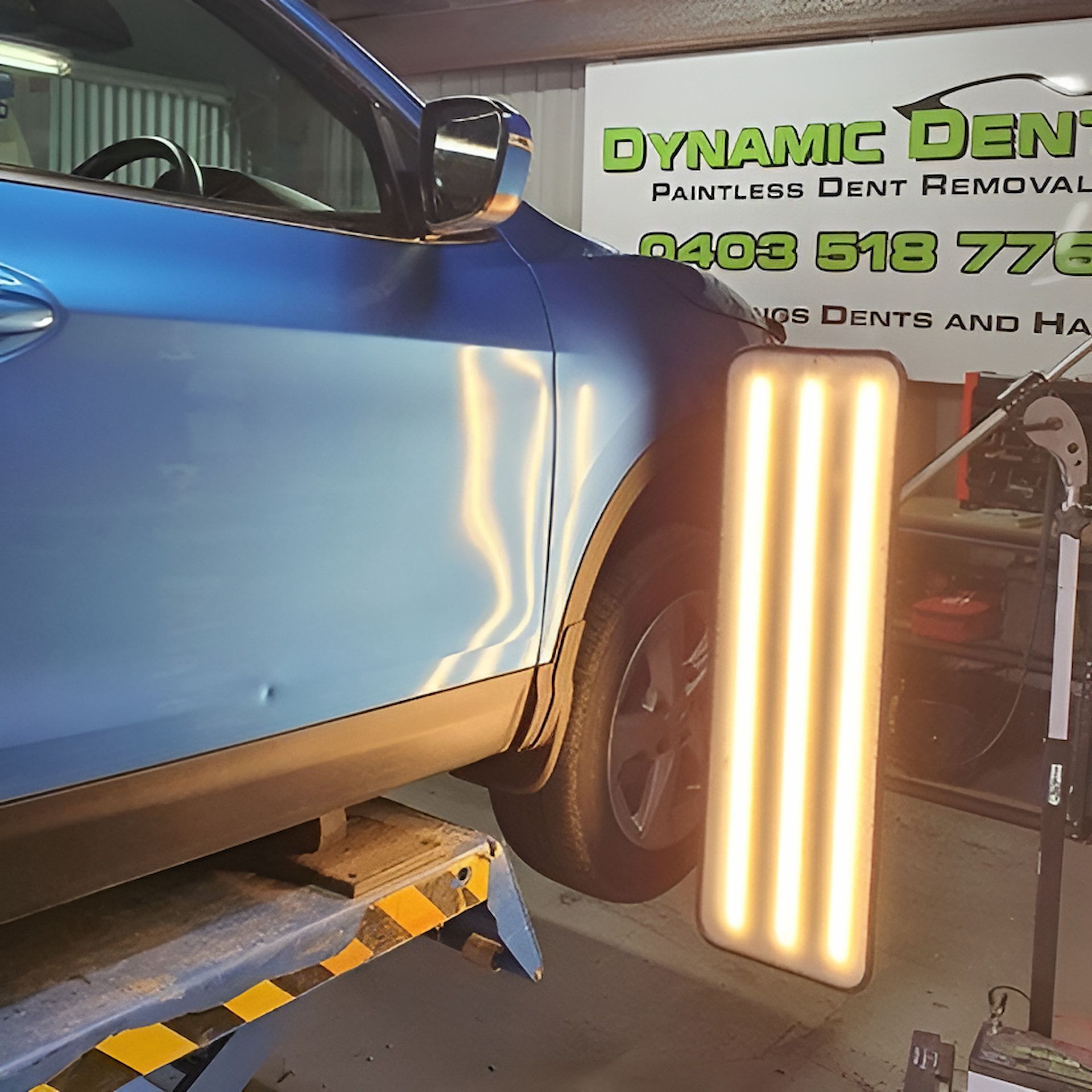 A Blue car with a light next to it — Dynamic Dentz Smash Repair in South Nowra, NSW