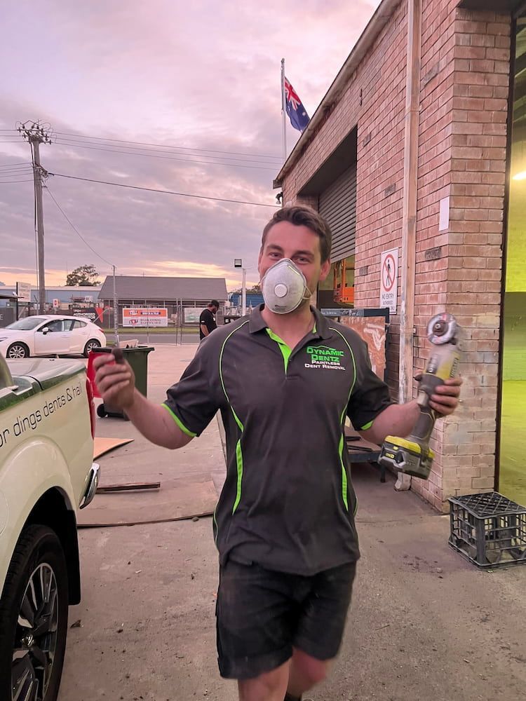A Man Wearing a Mask is Holding a Drill — Dynamic Dentz Smash Repair in South Nowra, NSW