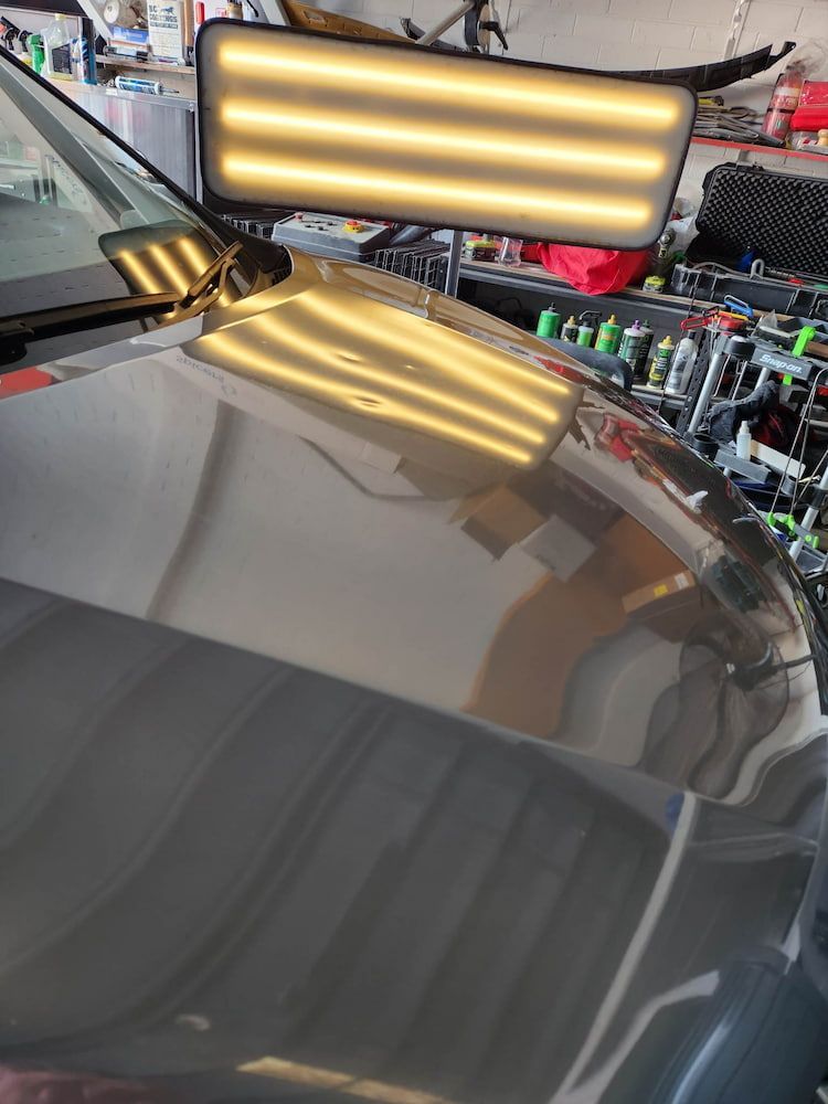 A Car With a Dent in the Hood is Sitting in a Garage — Dynamic Dentz Smash Repair in South Nowra, NSW