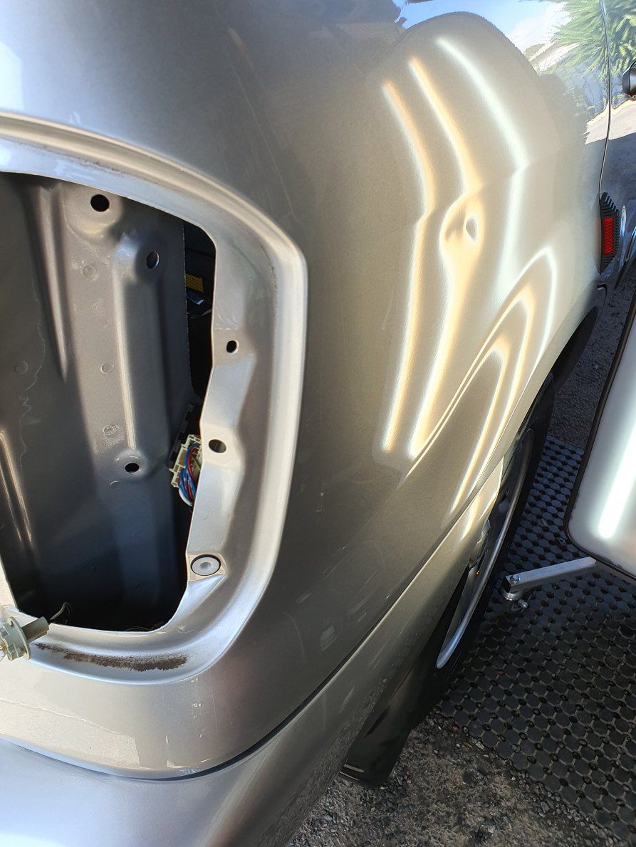 A Close Up of a Car 's Fender With a Dent in It — Dynamic Dentz Smash Repair in South Nowra, NSW