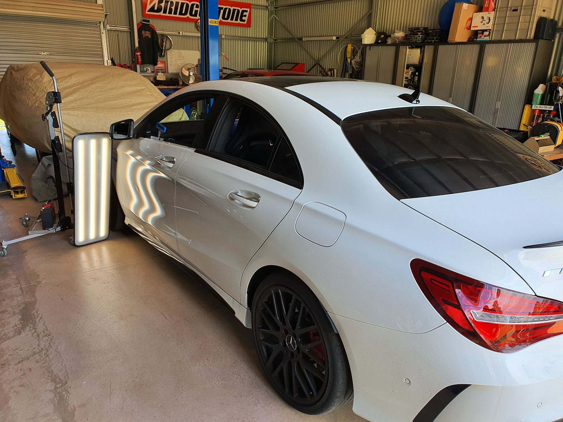 A white car has light shining on it — Dynamic Dentz Smash Repair in South Nowra, NSW