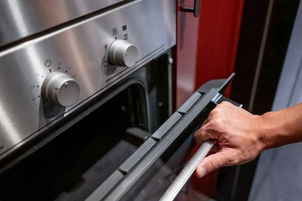 Person Opening the Door of a Stainless Steel Oven — SealTite in Ballina, NSW