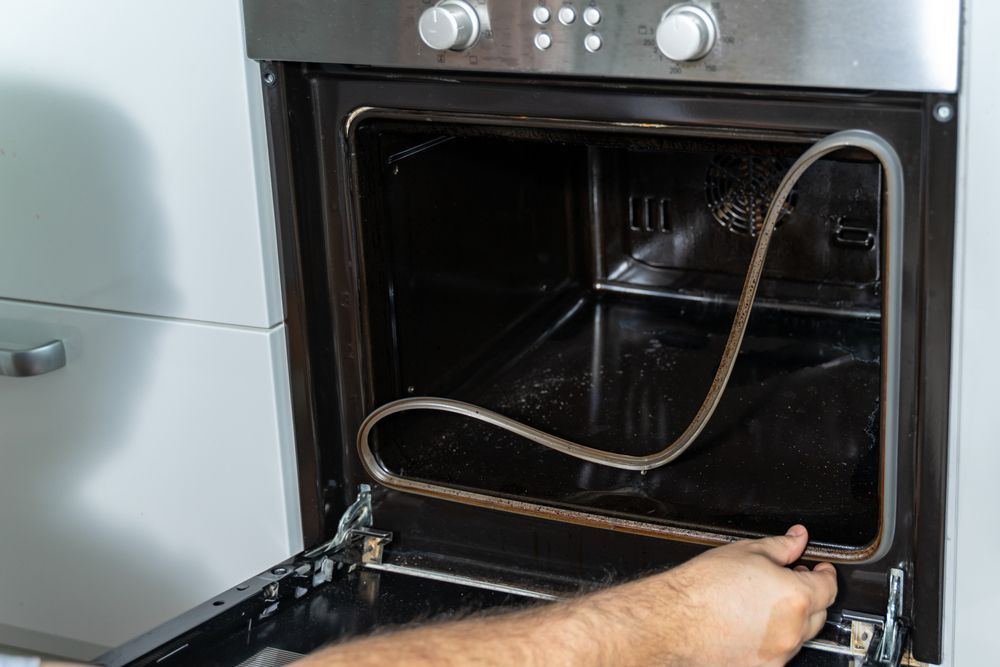 Open Oven With Hand Reaching in, Showing Heating Element, Interior View — SealTite in Lismore, NSW