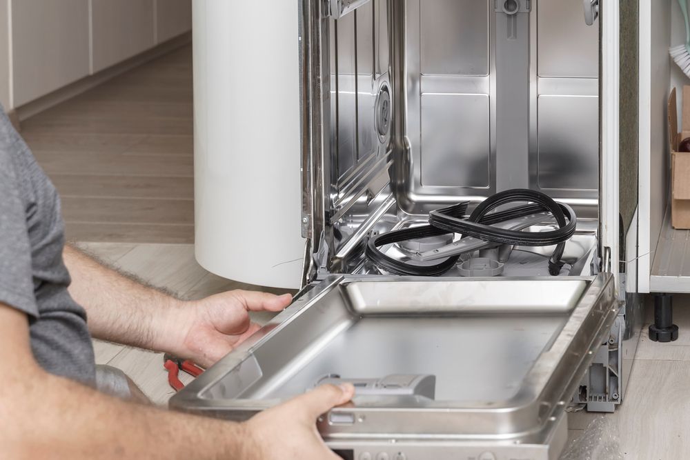 Person Removing Dishwasher Bottom Tray. Kitchen Setting — SealTite in Tweed Heads, NSW