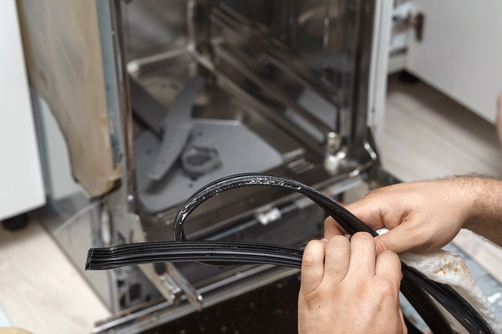 Person Replacing a Worn Dishwasher Door Seal Inside an Open Dishwasher — SealTite in Ballina, NSW
