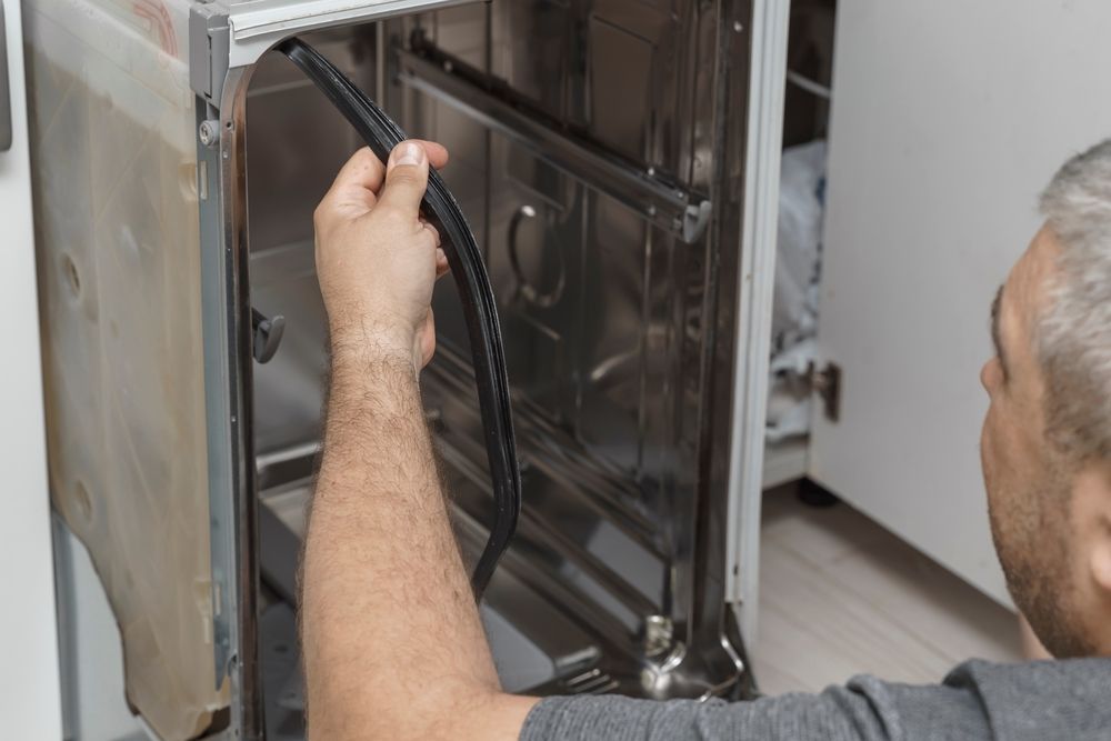 Person Replacing the Rubber Seal of a Stainless Steel Oven — SealTite in Gold Coast, QLD