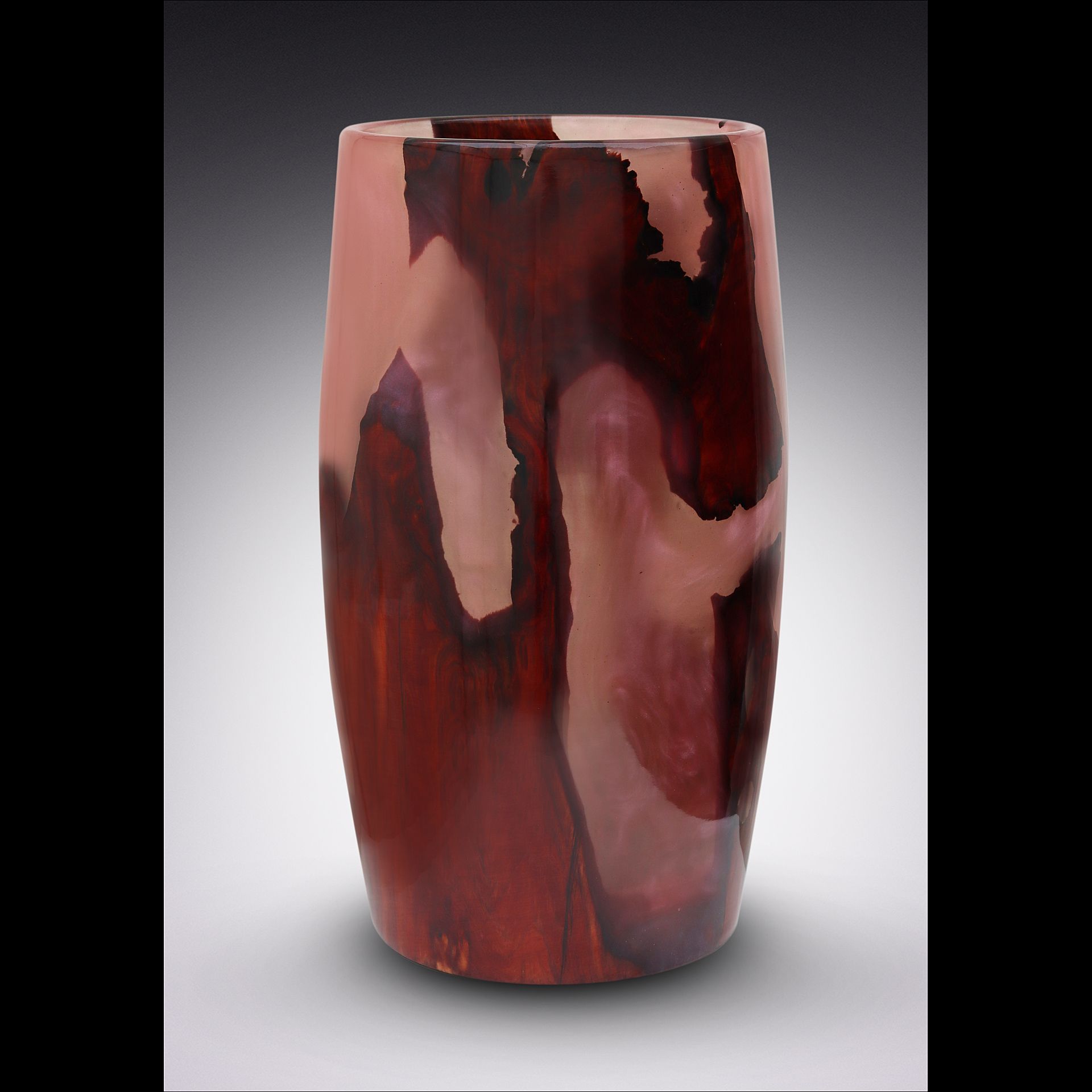 Vase made of wood and pink resin, with a dark wood grain pattern on a gray background.