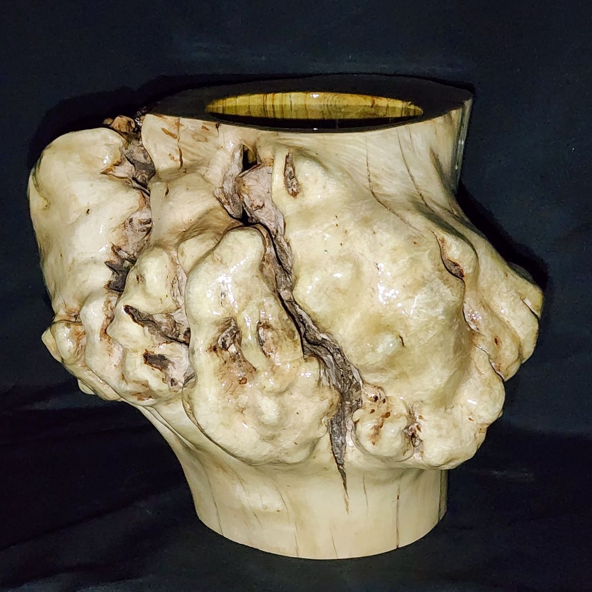 Wooden burl vase with a light brown and white color scheme, with a dark interior.