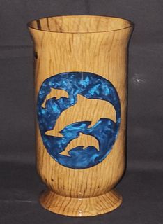 Tall, varnished wooden vase, standing upright on a dark, textured surface.