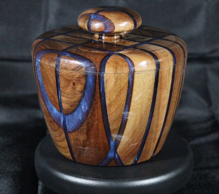Wooden box with blue accents, round shape. Brown wood with a lid.