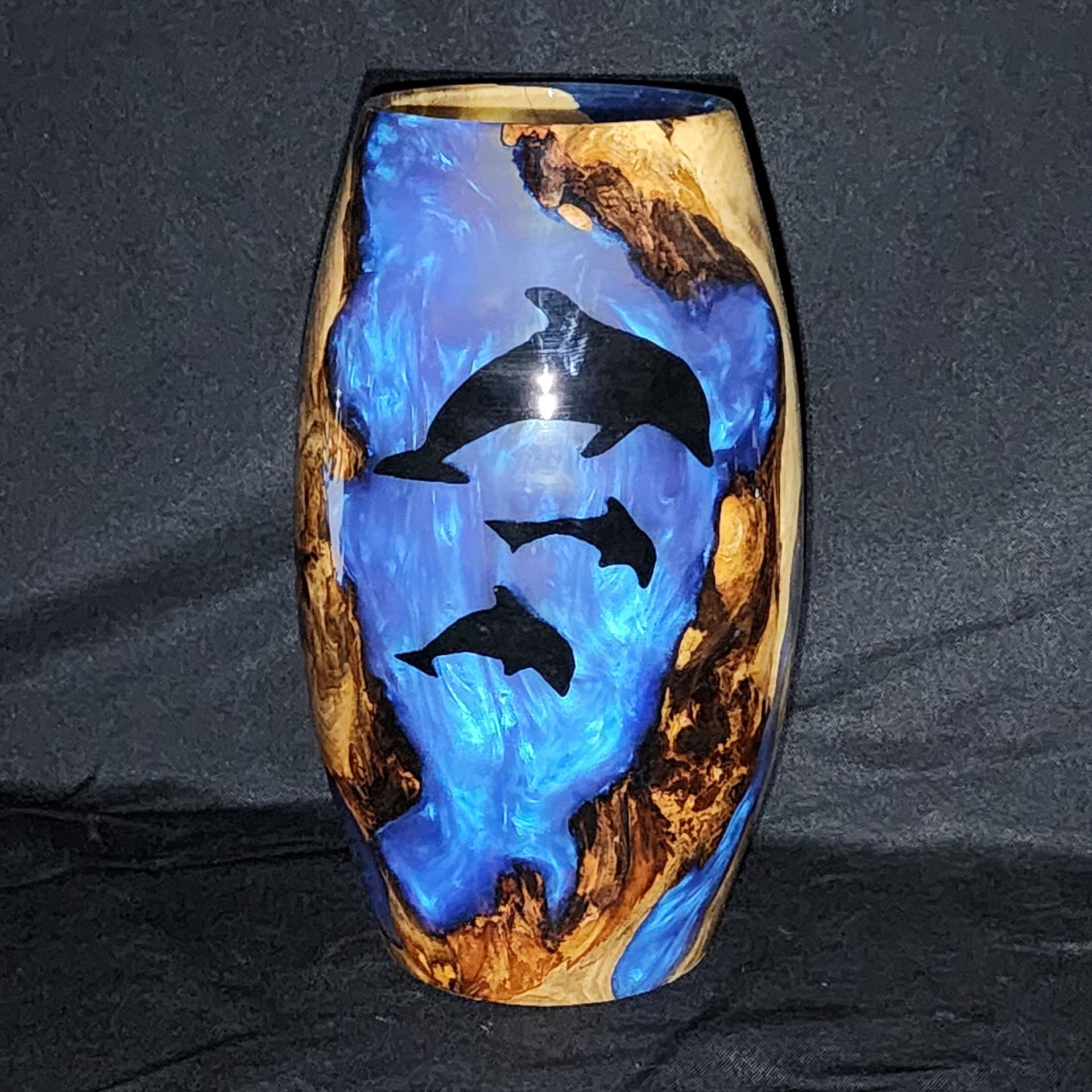 Wooden vase with blue resin interior and black dolphin silhouettes.
