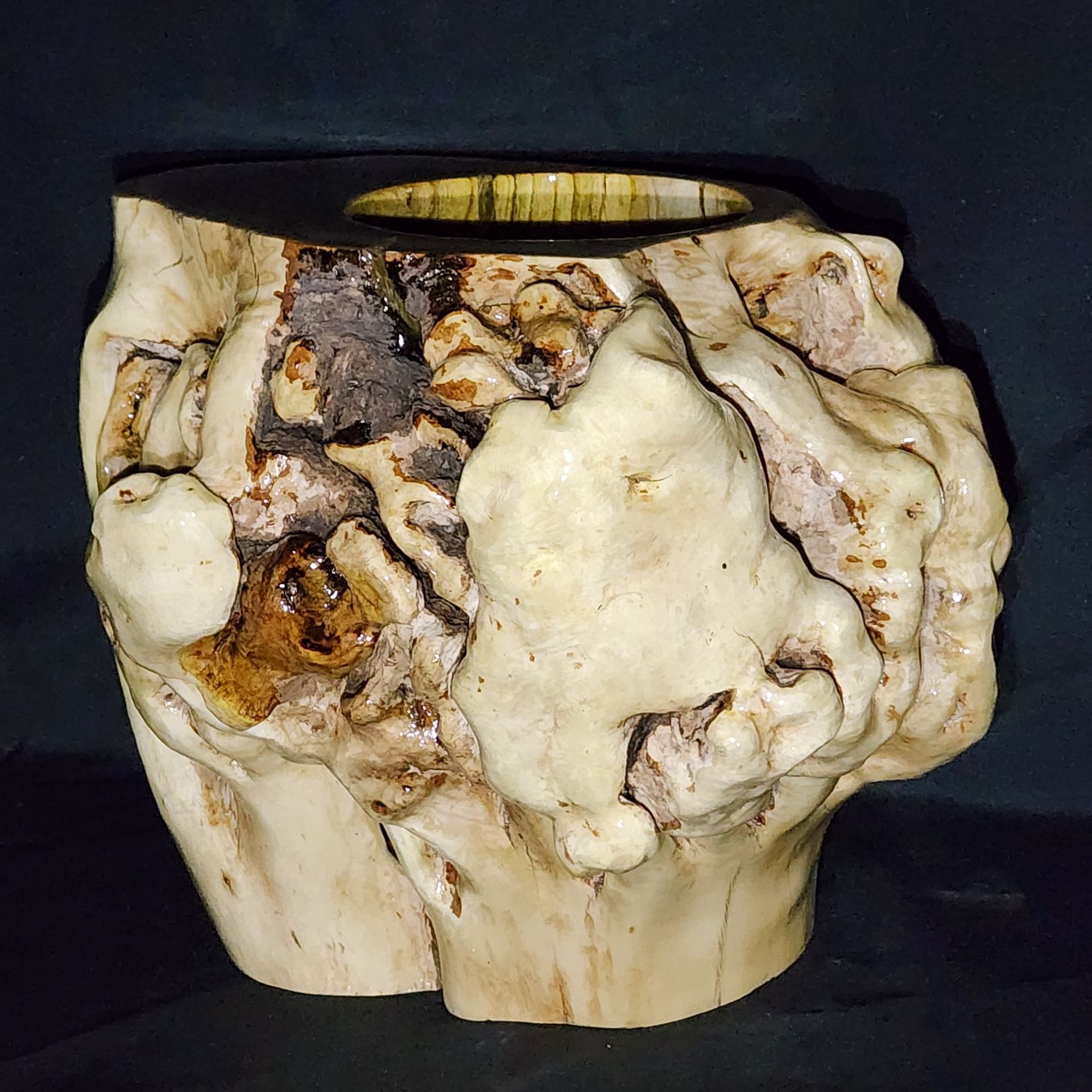 White and brown organic-shaped wooden vase with an open center.