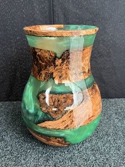 Green resin and wood vase with a bulbous shape.