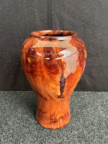 Wooden vase with swirling grain, finished with glossy varnish.
