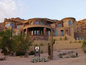 A large house with a cactus in front of it