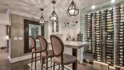 A wine cellar with a table and chairs and lots of wine bottles.